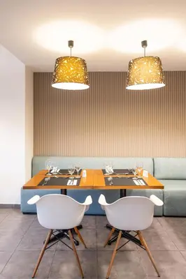 a dining room with two tables and a couch at Amphitryon City Hotel in Rhodes Town