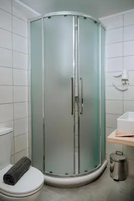 a glass shower in a bathroom with a toilet at Amphitryon City Hotel in Rhodes Town