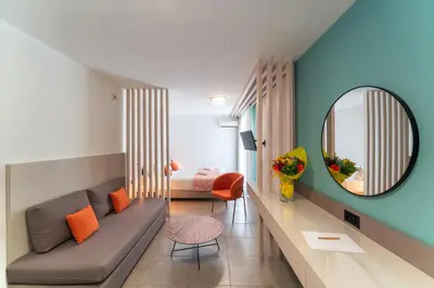 a living room with a couch and a mirror at Amphitryon City Hotel in Rhodes Town