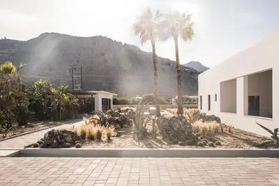a building with palm trees and a mountain in the background at Casa Cook Rhodes (Adults Only) in Kolimbia