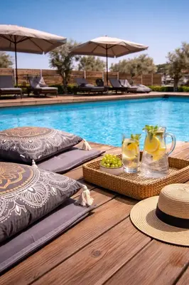 a table with a tray of fruit and drinks next to a swimming pool at Villa Photerra, A Luxury familly Villa with pool in Koskinou