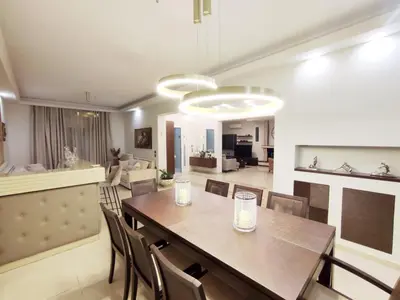 a dining room and living room with a table and chairs at Villa Photerra, A Luxury familly Villa with pool in Koskinou