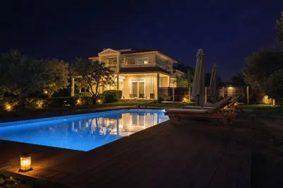 a house with a swimming pool at night at Villa Photerra, A Luxury familly Villa with pool in Koskinou