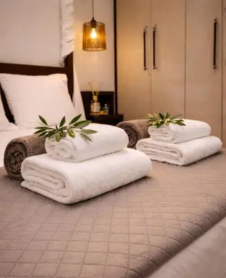 three towels on a bed in a hotel room at Villa Photerra, A Luxury familly Villa with pool in Koskinou