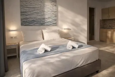 a bedroom with a large white bed with towels on it at Casa al'tati studios in Ialyssos