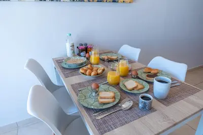 a table with breakfast foods and orange juice on it at Residence City Luna in Rhodes Town