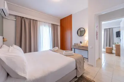 a bedroom with a large white bed and a bathroom at Residence City Luna in Rhodes Town
