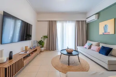 a living room with a couch and a tv at Residence City Frida in Rhodes Town