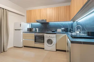 a kitchen with a washing machine and a refrigerator at Residence City Retreat in Rhodes Town