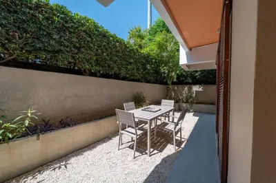 a patio with a table and chairs and a hedge at Residence City Retreat in Rhodes Town