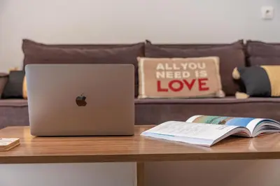 a table with a laptop and a book on it at Residence City Retreat in Rhodes Town
