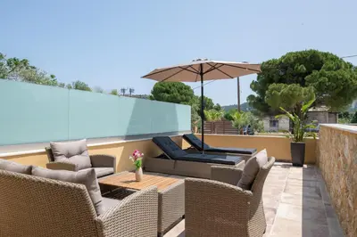 a patio with wicker chairs and a table and an umbrella at Anthi Luxury Residence in Triánta