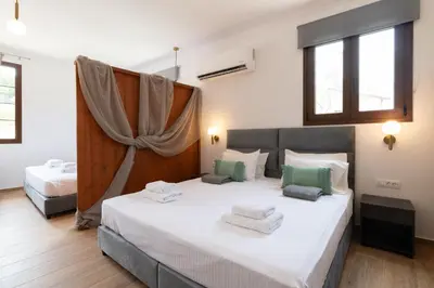 a bedroom with two beds and two windows at Anthi Luxury Residence in Triánta