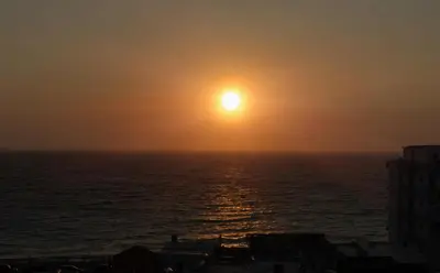 a sunset over the ocean with the sun in the sky at Casa di Anna Seaside in Rhodes Town