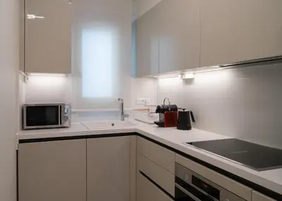 a kitchen with white cabinets and a microwave at Casa di Anna Seaside in Rhodes Town