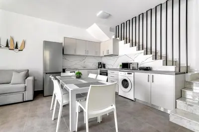 a kitchen with a table and chairs and a staircase at Gennadi GEMS Villas in Gennadi