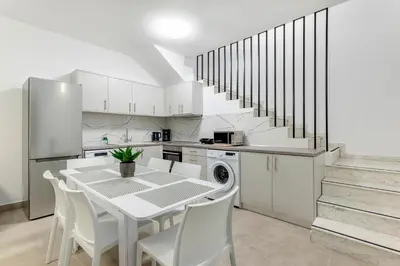 a white kitchen with a table and white chairs at Gennadi GEMS Villas in Gennadi