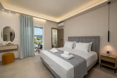 a bedroom with a large white bed with two towels at Central Avenue Studios in Kremasti