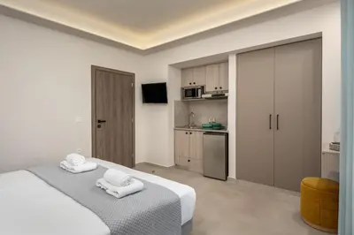 a bedroom with a bed with two towels on it at Central Avenue Studios in Kremasti