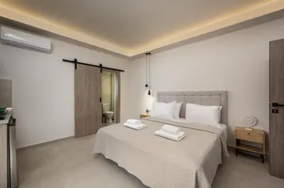 a bedroom with a bed with two towels on it at Central Avenue Studios in Kremasti