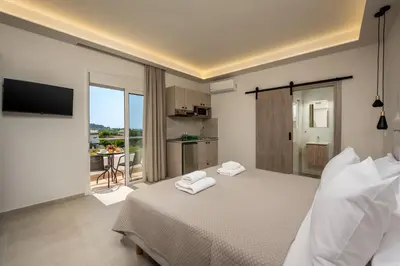 a hotel room with a bed with towels on it at Central Avenue Studios in Kremasti