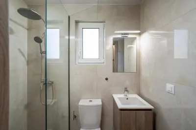 a bathroom with a toilet and a sink and a shower at Central Avenue Studios in Kremasti