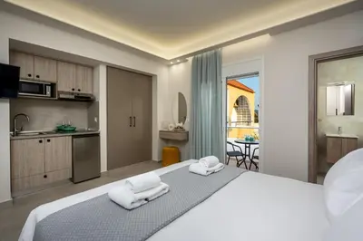 a bedroom with a large bed with two towels at Central Avenue Studios in Kremasti