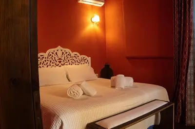 a bedroom with a bed with white sheets and towels at Ottoman's Manor in Rhodes Town
