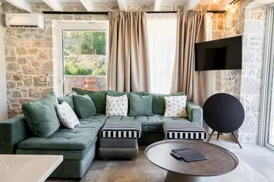 a living room with a green couch and a tv at Villa Splendide in Rhodes Town
