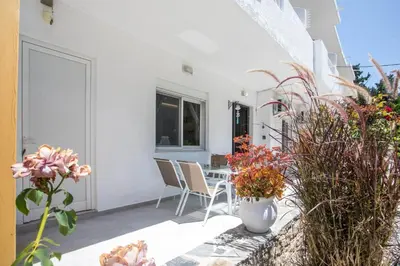 a patio with a table and chairs and flowers at PaMar in Faliraki