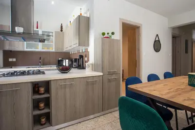 a kitchen with wooden cabinets and a table with chairs at PaMar in Faliraki