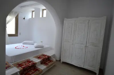 a bedroom with a bed and a large white cabinet at Bianca Suite & Home in Psinthos