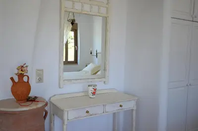 a white dressing table with a mirror on a wall at Bianca Suite & Home in Psinthos