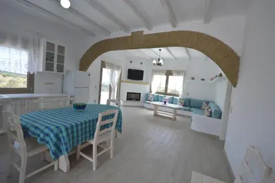 a kitchen and a dining room with a table and a living room at Bianca Suite & Home in Psinthos