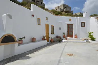 a white house with a courtyard with potted plants at Bianca Suite & Home in Psinthos
