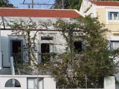 a white building with a tree in front of it at MAÏA's House in Symi