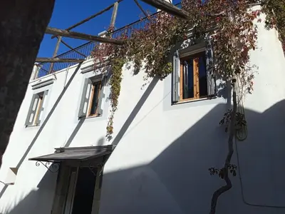a white building with two windows and a tree at MAÏA's House in Symi