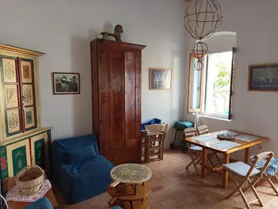 a living room with a blue couch and a table at MAÏA's House in Symi