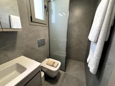 a bathroom with a white toilet and a sink at Date Palm Studio in Kremasti