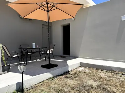 a patio with a table and an umbrella at Date Palm Studio in Kremasti