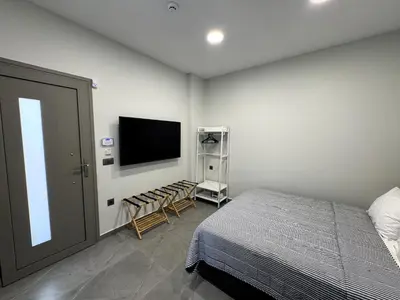 a bedroom with a bed and a flat screen tv at Date Palm Studio in Kremasti