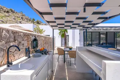 a kitchen with a sink and a stone wall at Villa Zen Koan in Kolimbia