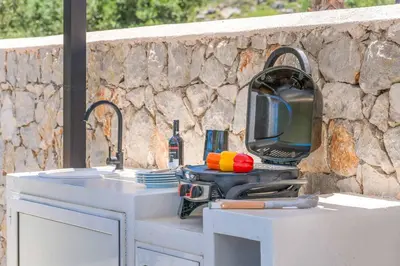 a kitchen with a sink and a tv on a counter at Villa Zen Koan in Kolimbia