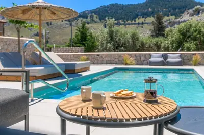a table with a plate of food next to a pool at Villa Zen Koan in Kolimbia