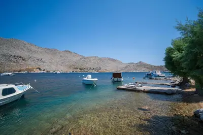 a group of boats docked in a body of water at Mythos House - Seaside Retreat in Pedi in Symi