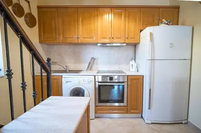 a kitchen with a white refrigerator and a dishwasher at Mythos House - Seaside Retreat in Pedi in Symi