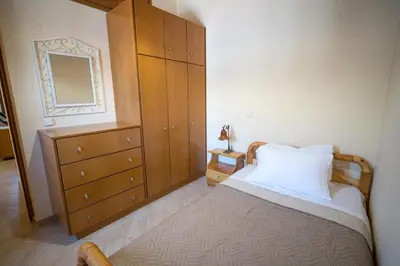 a bedroom with a bed with a dresser and a mirror at Mythos House - Seaside Retreat in Pedi in Symi