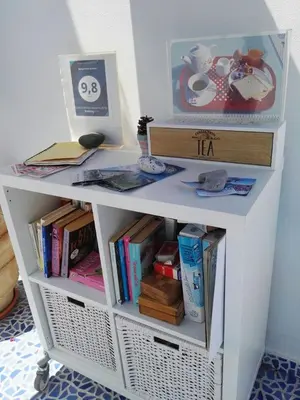 a white book shelf with books on it at Bouganville Studios Stegna in Archangelos