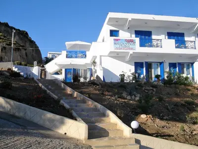 a white house with stairs in front of it at Bouganville Studios Stegna in Archangelos