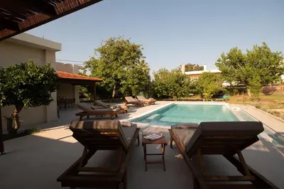 a patio with chairs and a swimming pool at Casa Alini in Ialyssos